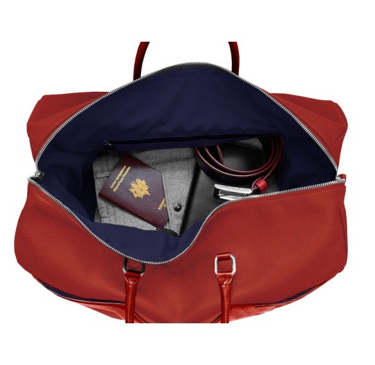 Intérieur sac de voyage cuir rouge liseré bleu blanc.
